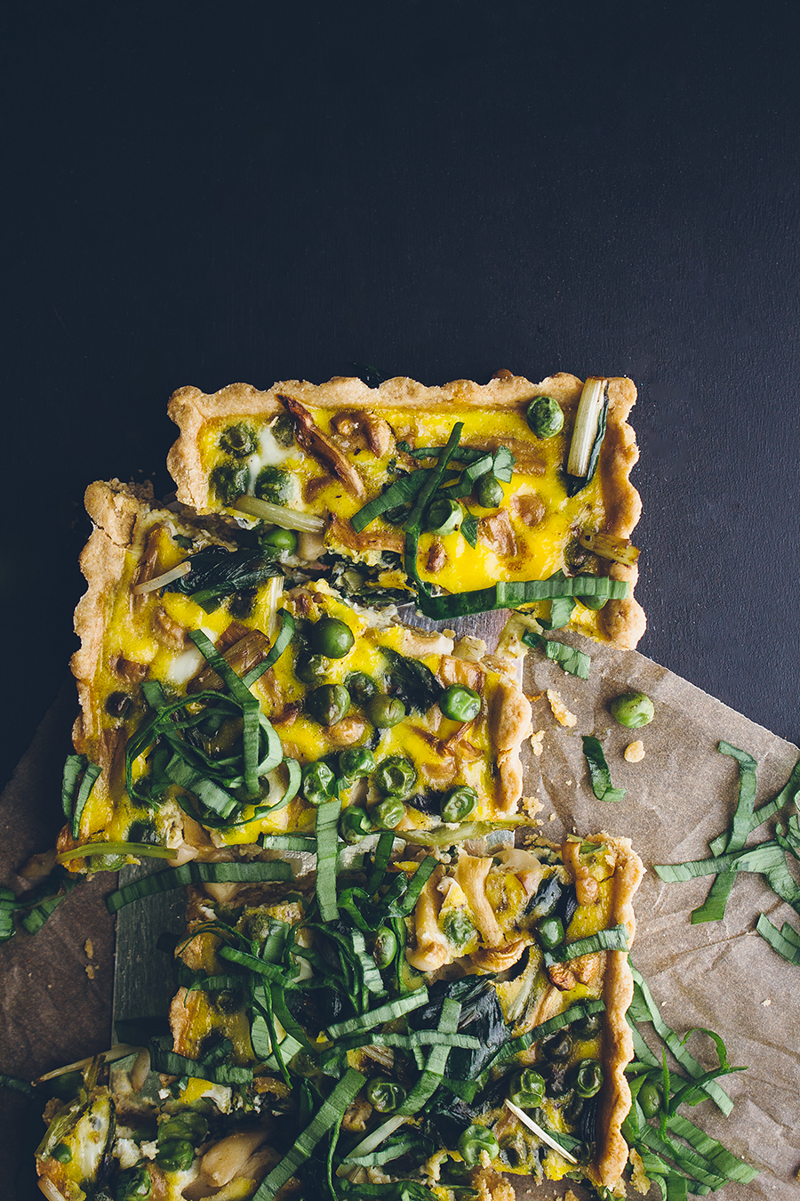 loaded vegetable quiche on brown towel