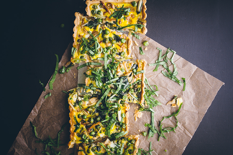 vegetable quiche sliced atop parchment paper