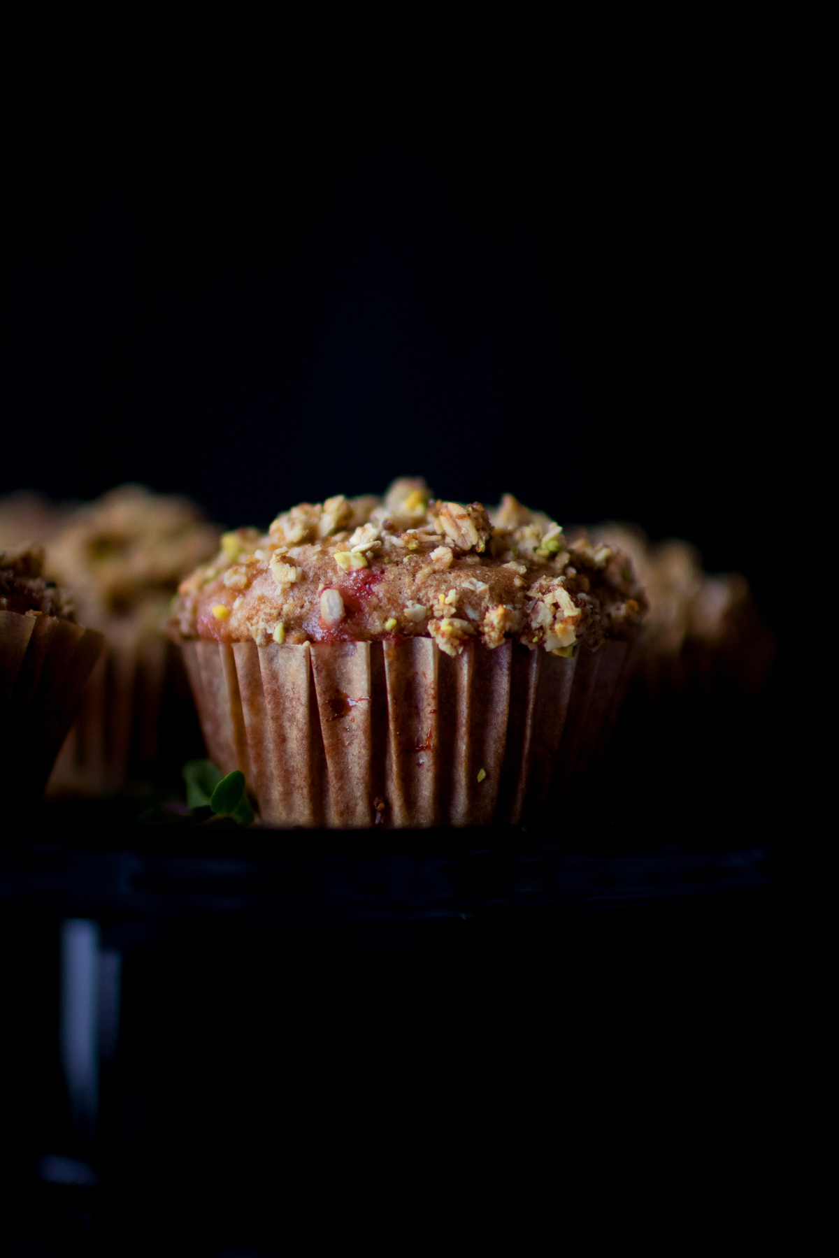 strawberry rhubarb muffins against dark backdrop