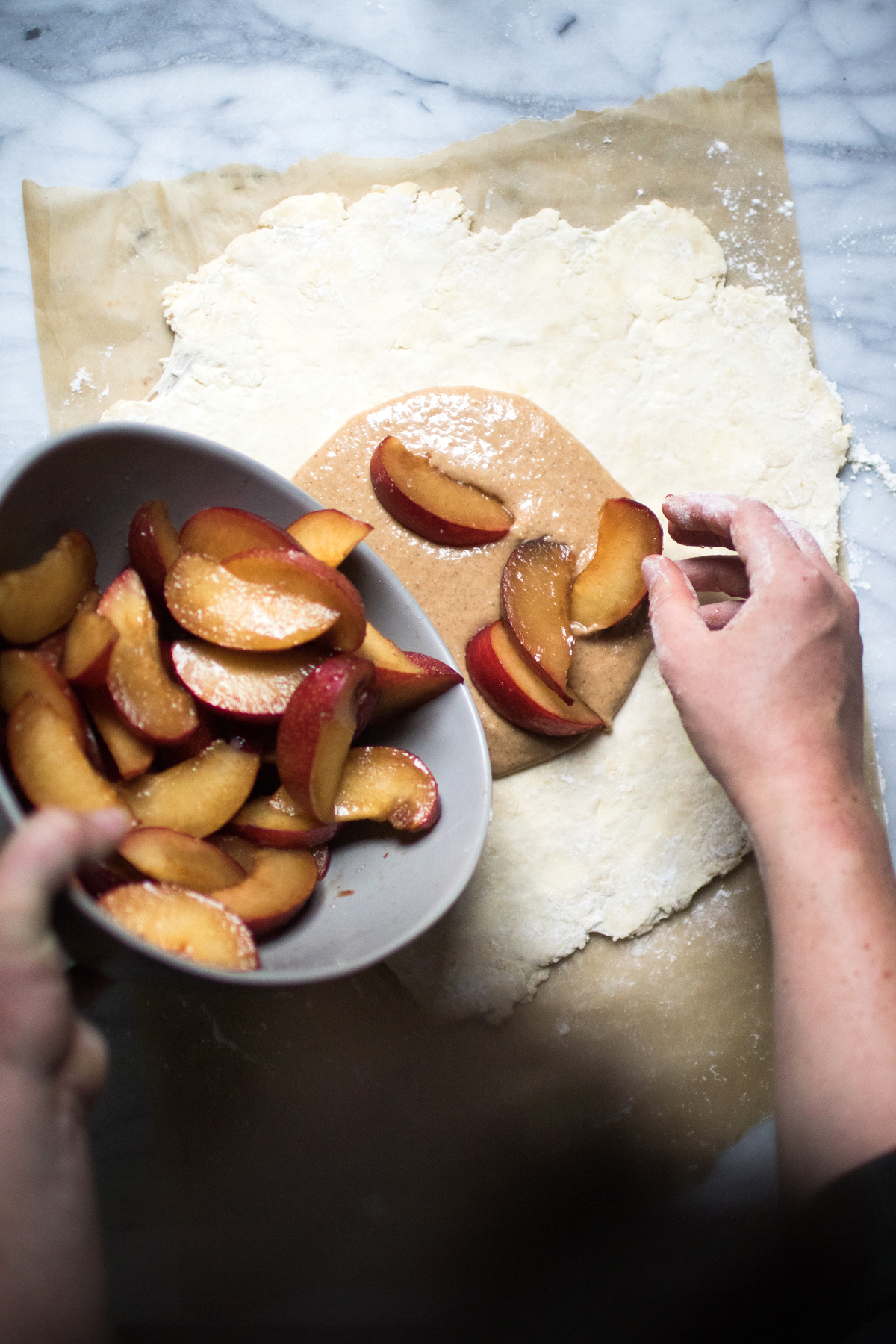 topping a plum galette with filling