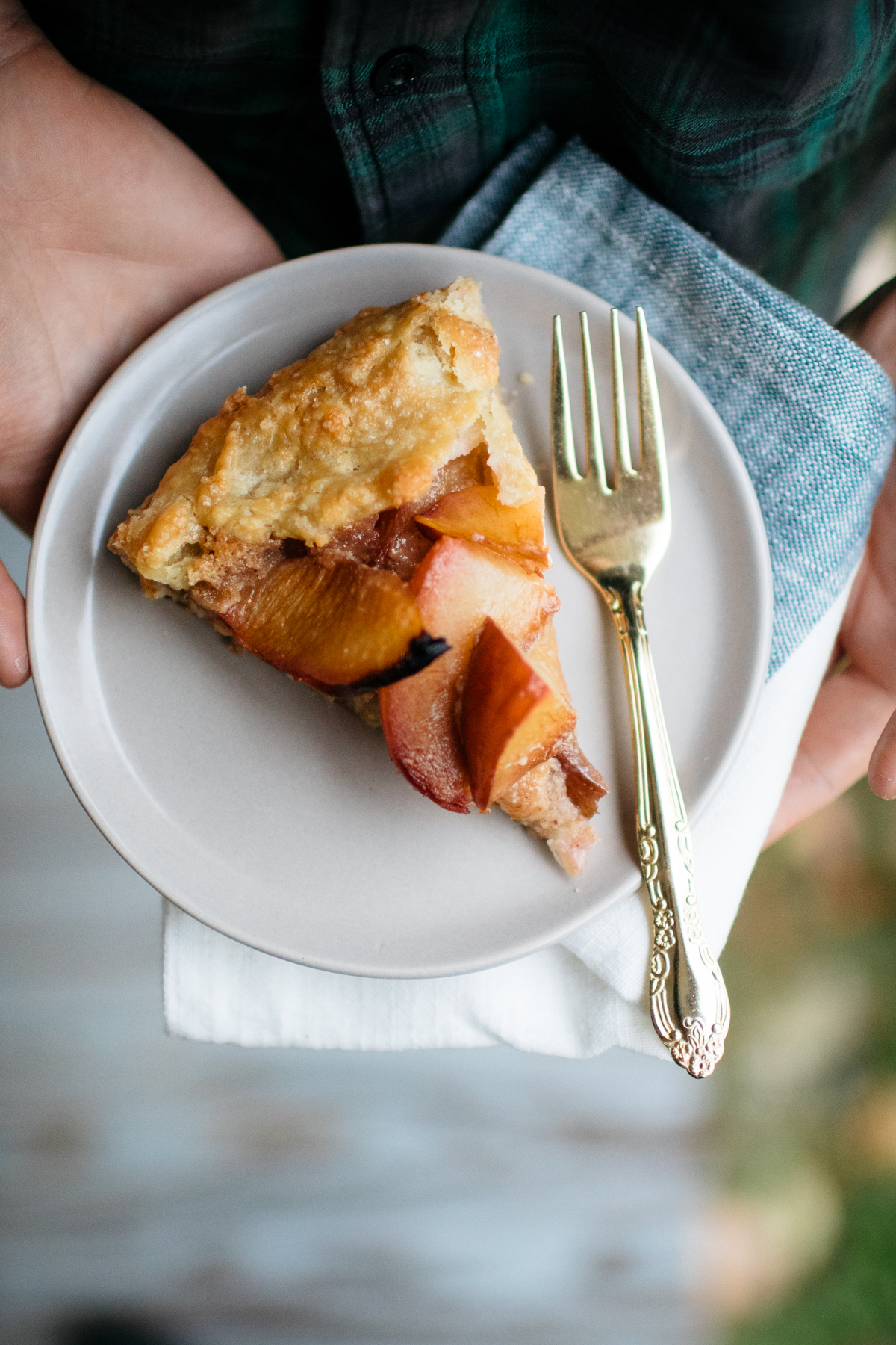 slice of plum galette on white plate with fork