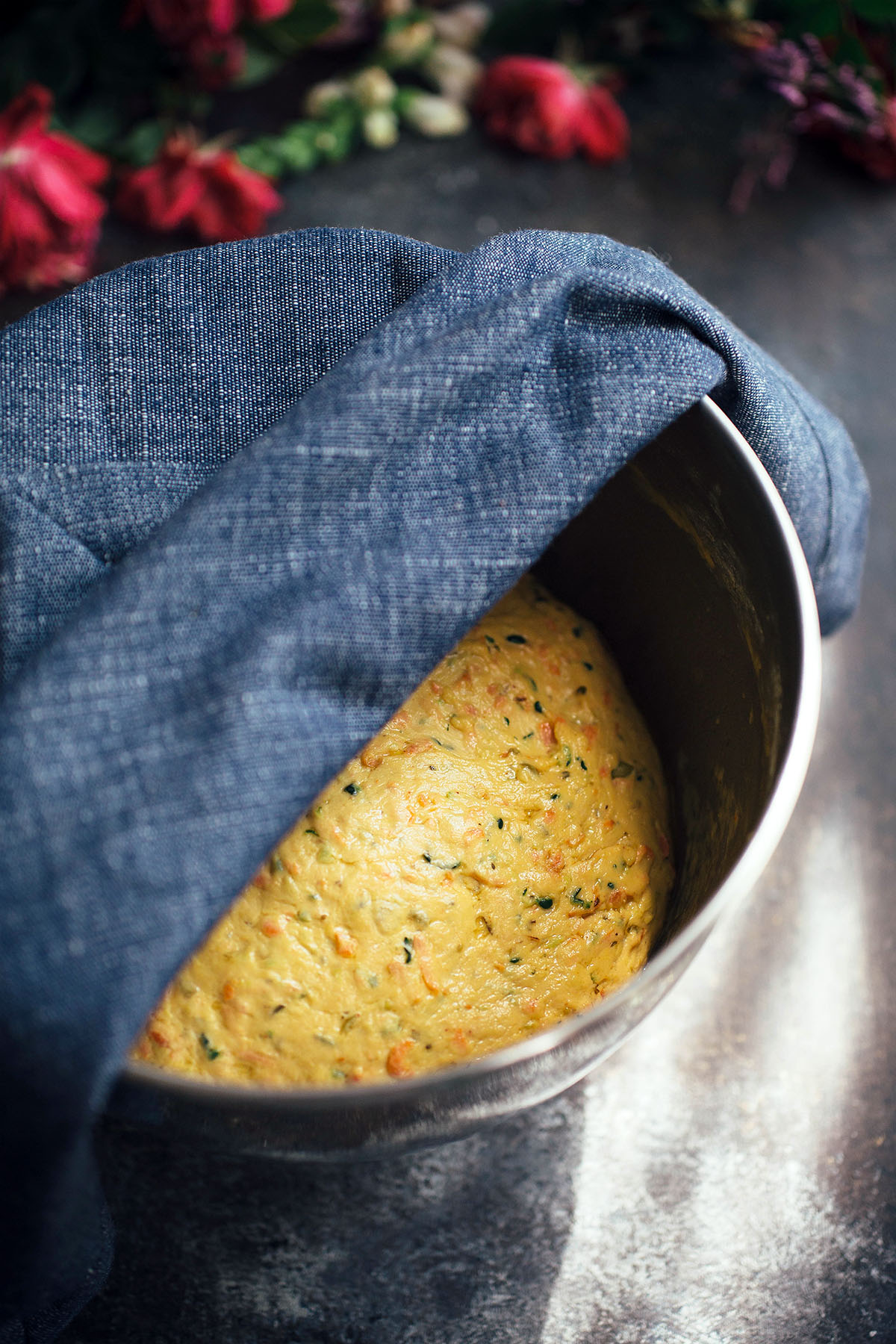 vegetable bread dough in bowl topped with tea towel