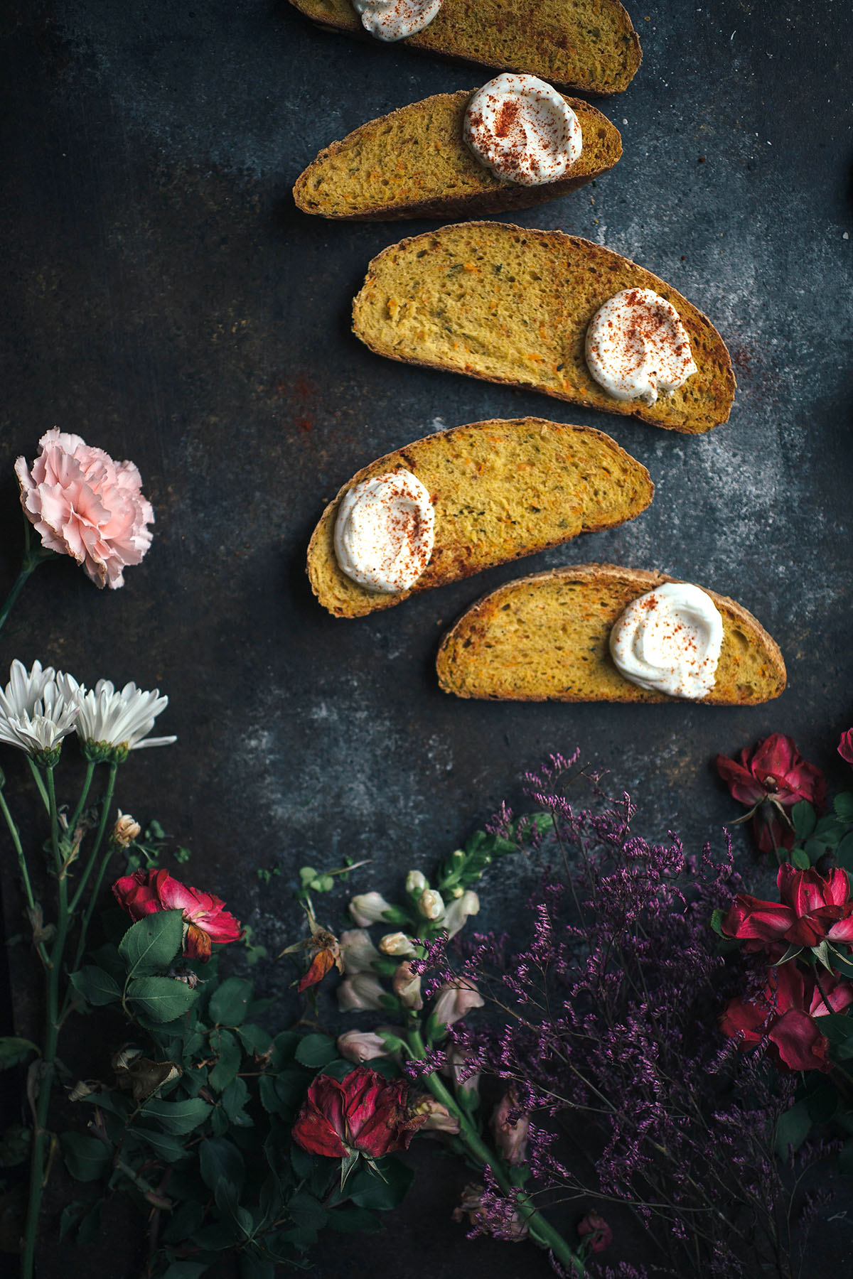 slices of vegetable bread topped with yogurt next to flowers