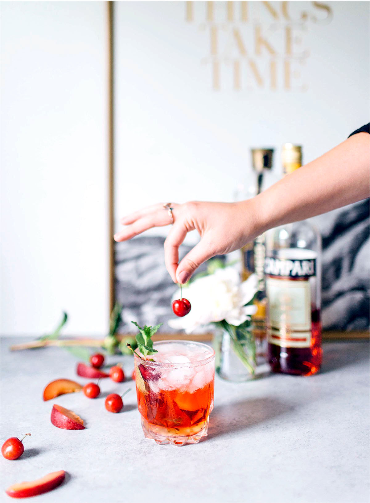 placing a cherry stop a st. germain spritz cocktail