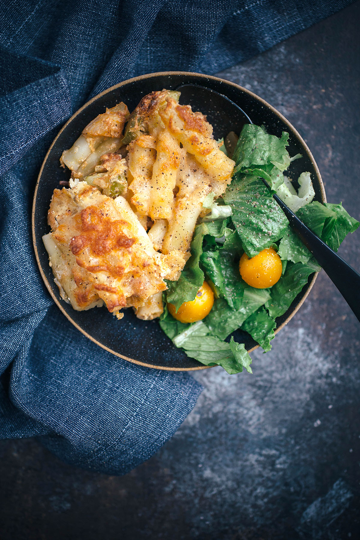 portion of Vegetarian Baked Ziti with side salad on dark plate