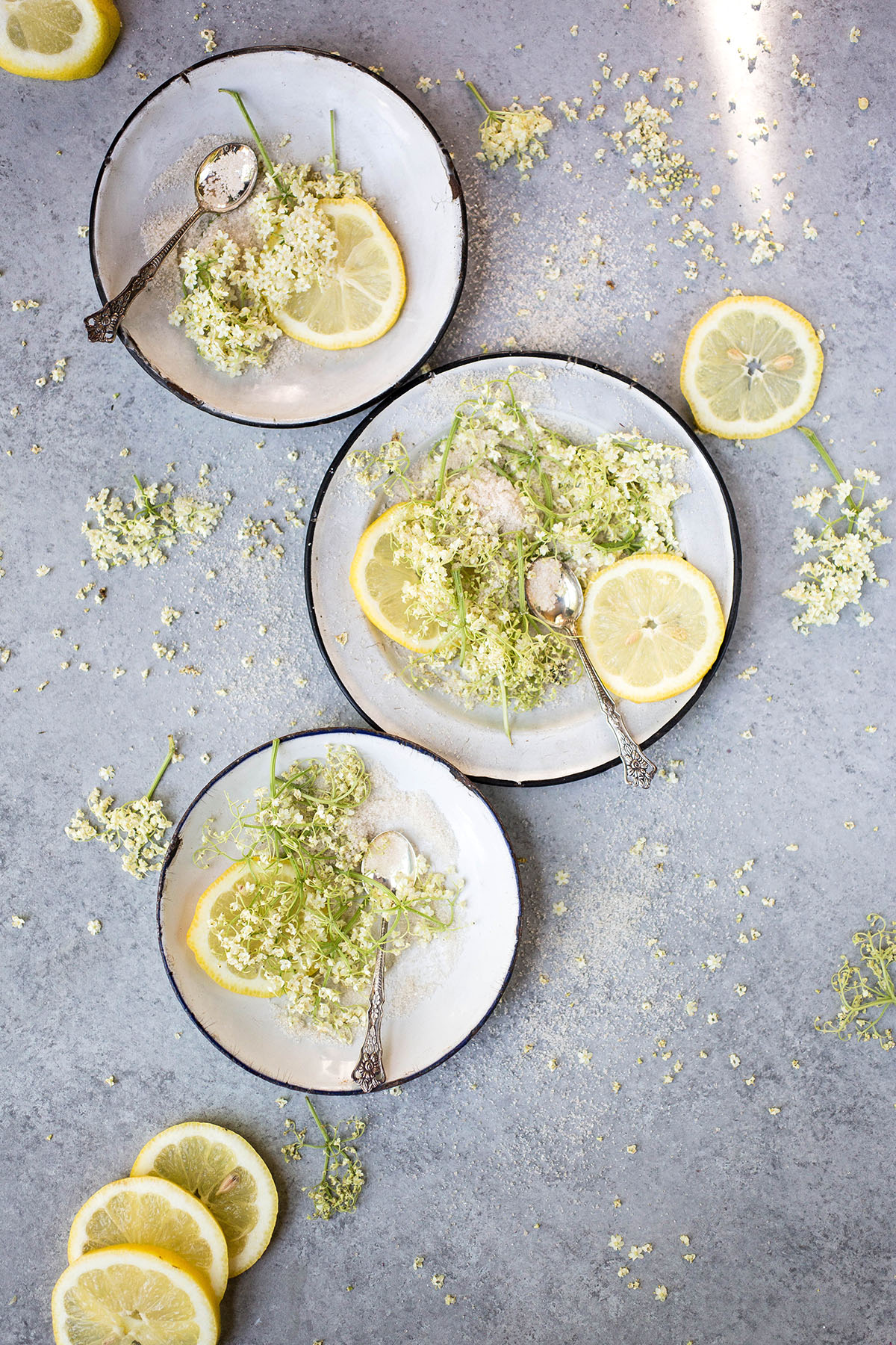 three plates of sugar, elderflower blossoms, and lemon slices