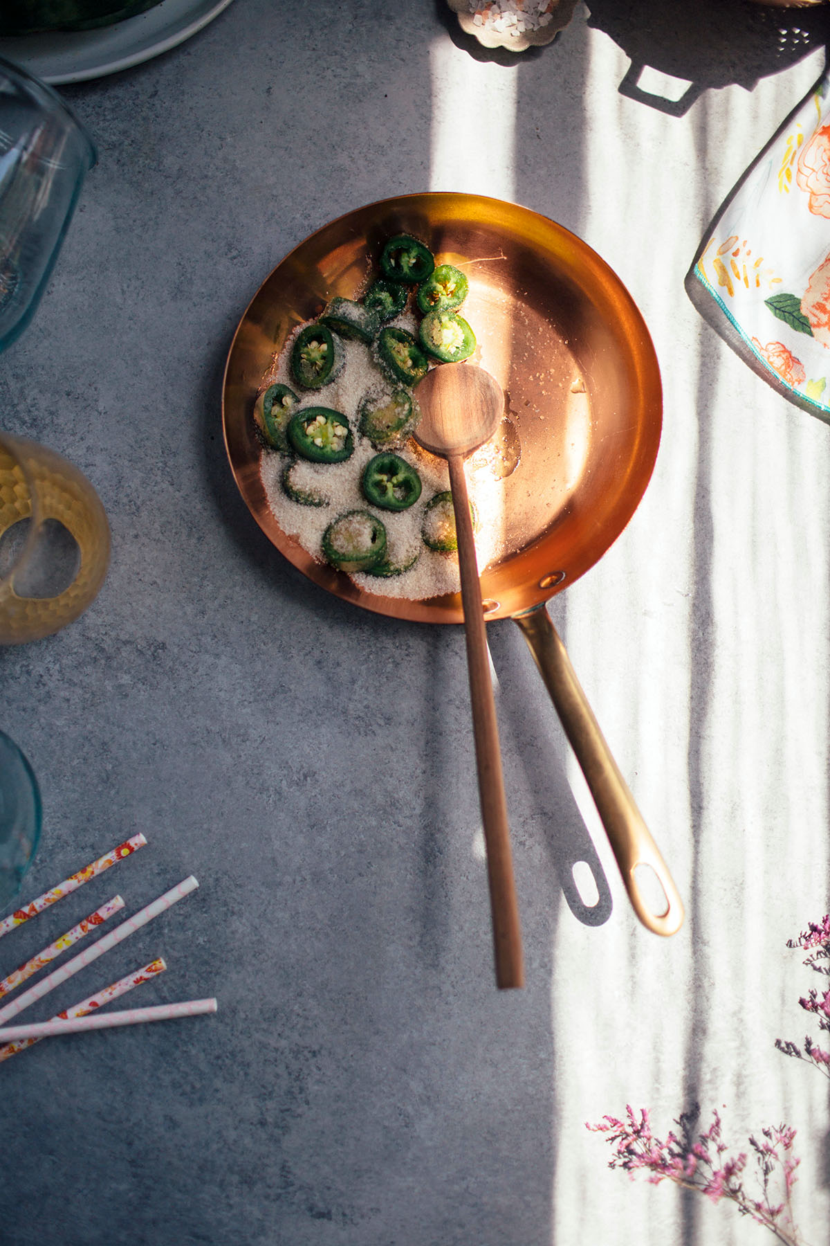 sliced jalapeno and sugar in copper pan