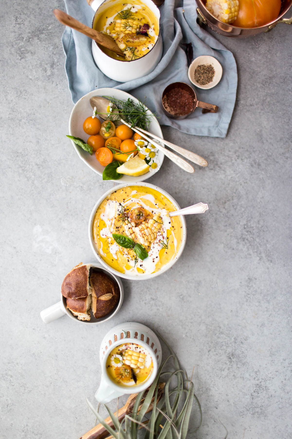 sweet corn and tomato gazpacho divided between a bowl and two small pitchers