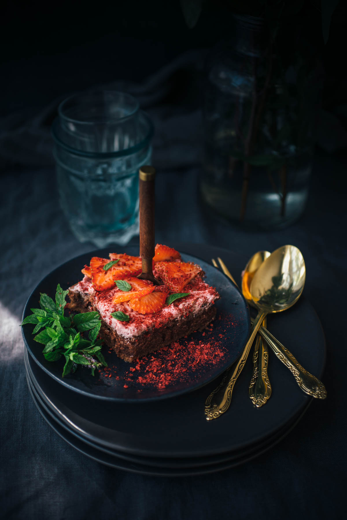 slice of Chocolate Sheet Cake on stack of dark gray plates