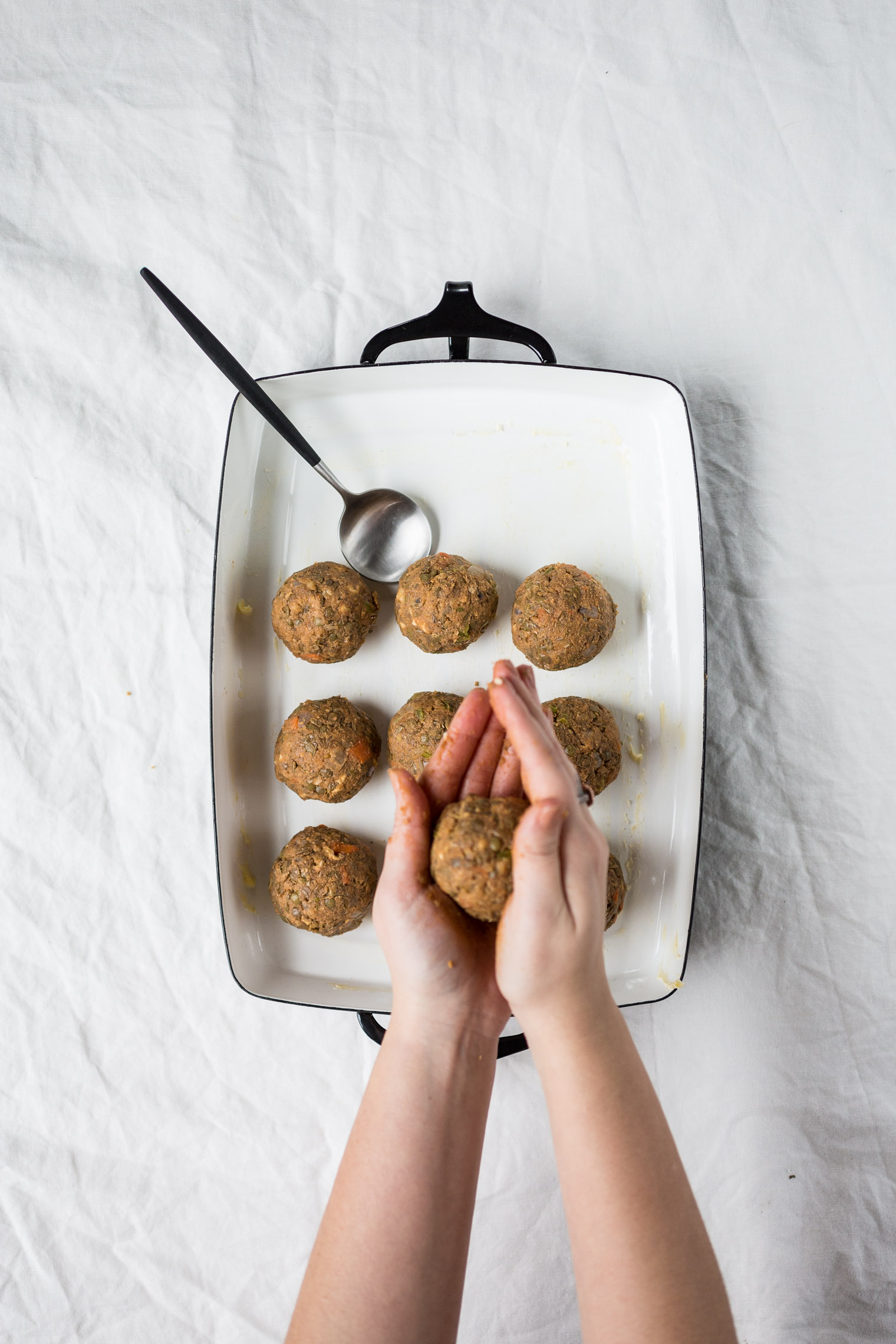 rolling vegetarian meatballs to place in baking dish