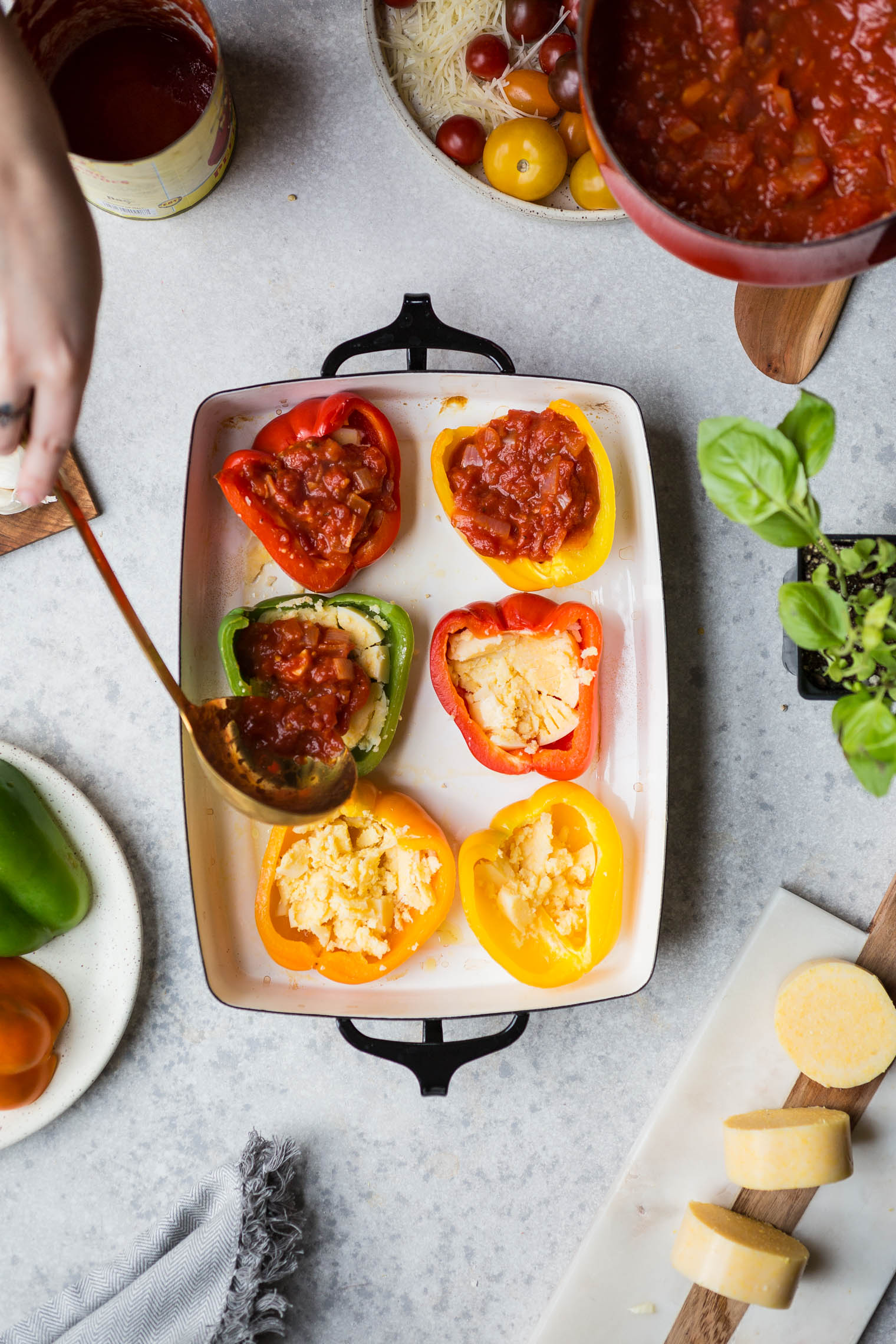 ladling tomato sauce into pizza stuffed bell pepper halves