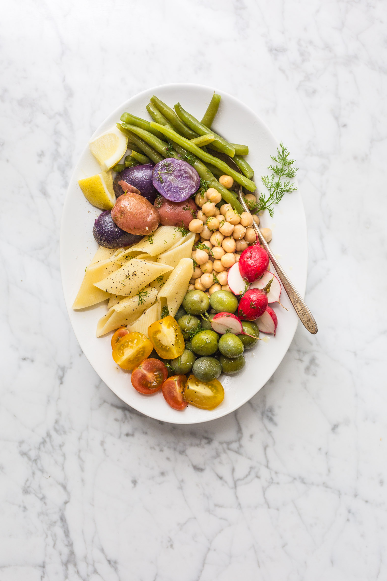 dill pasta salad on white serving platter with fork