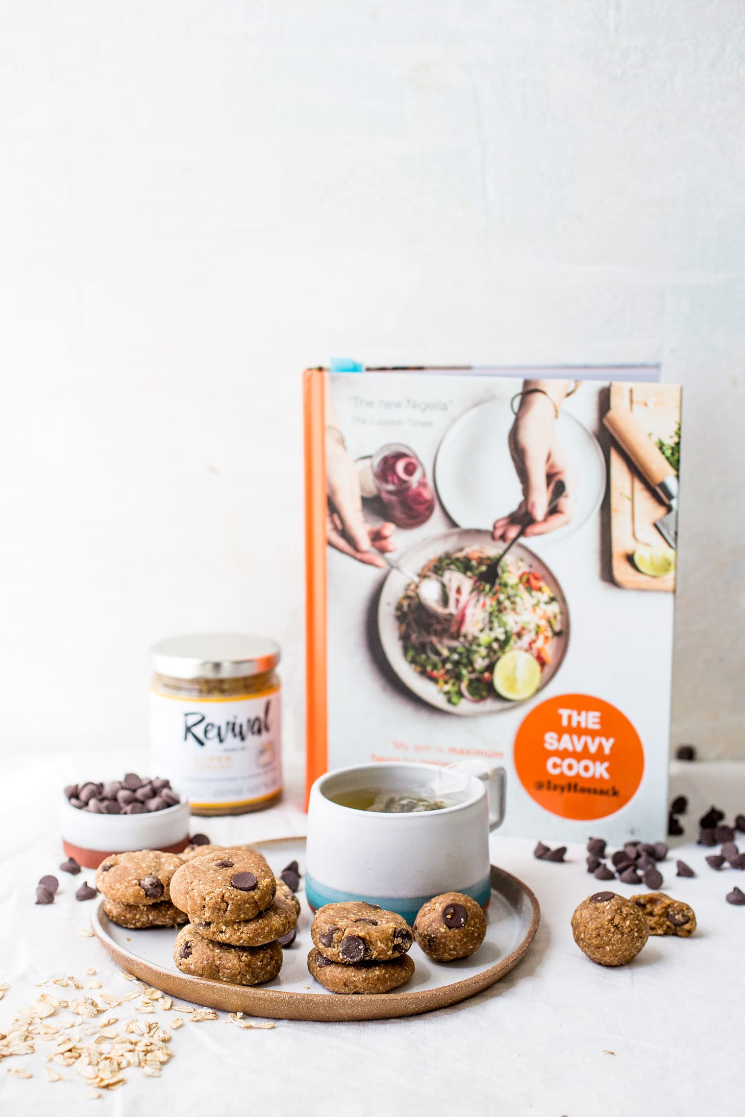 healthy Cookie Dough Balls on plate with mug in front of savvy cook cookbook