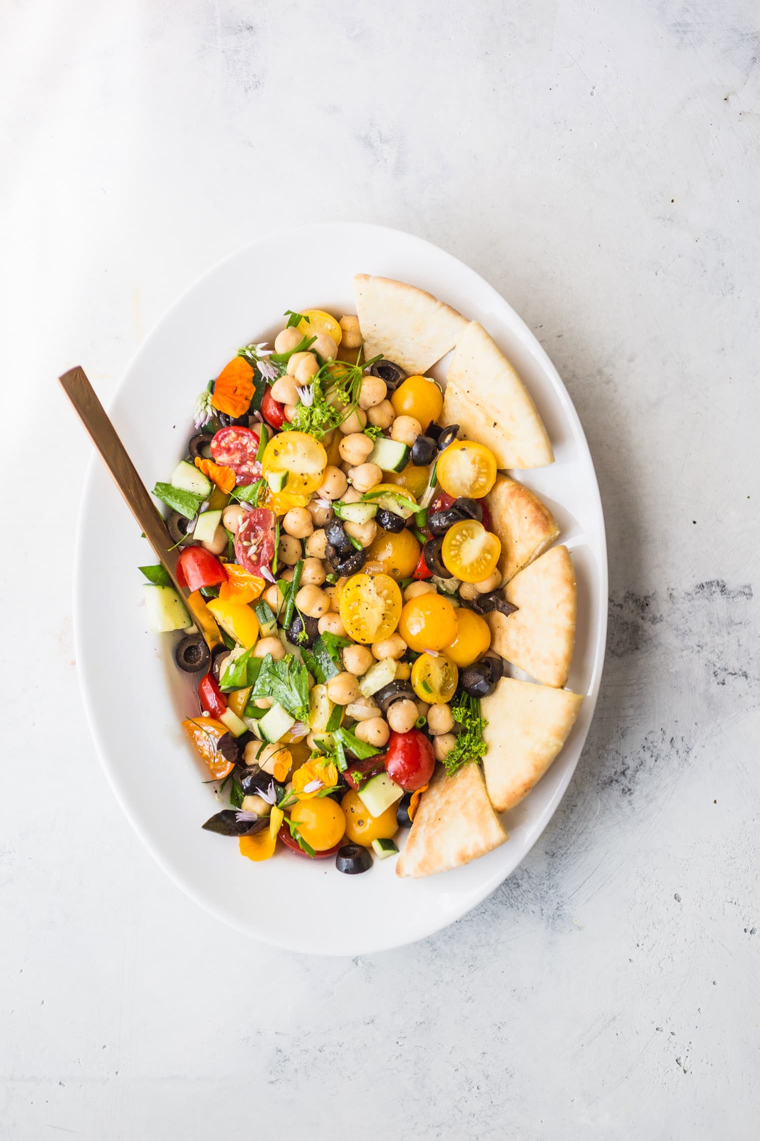 Fresh Greek Nachos with Herbed Tahini Sauce on white serving platter