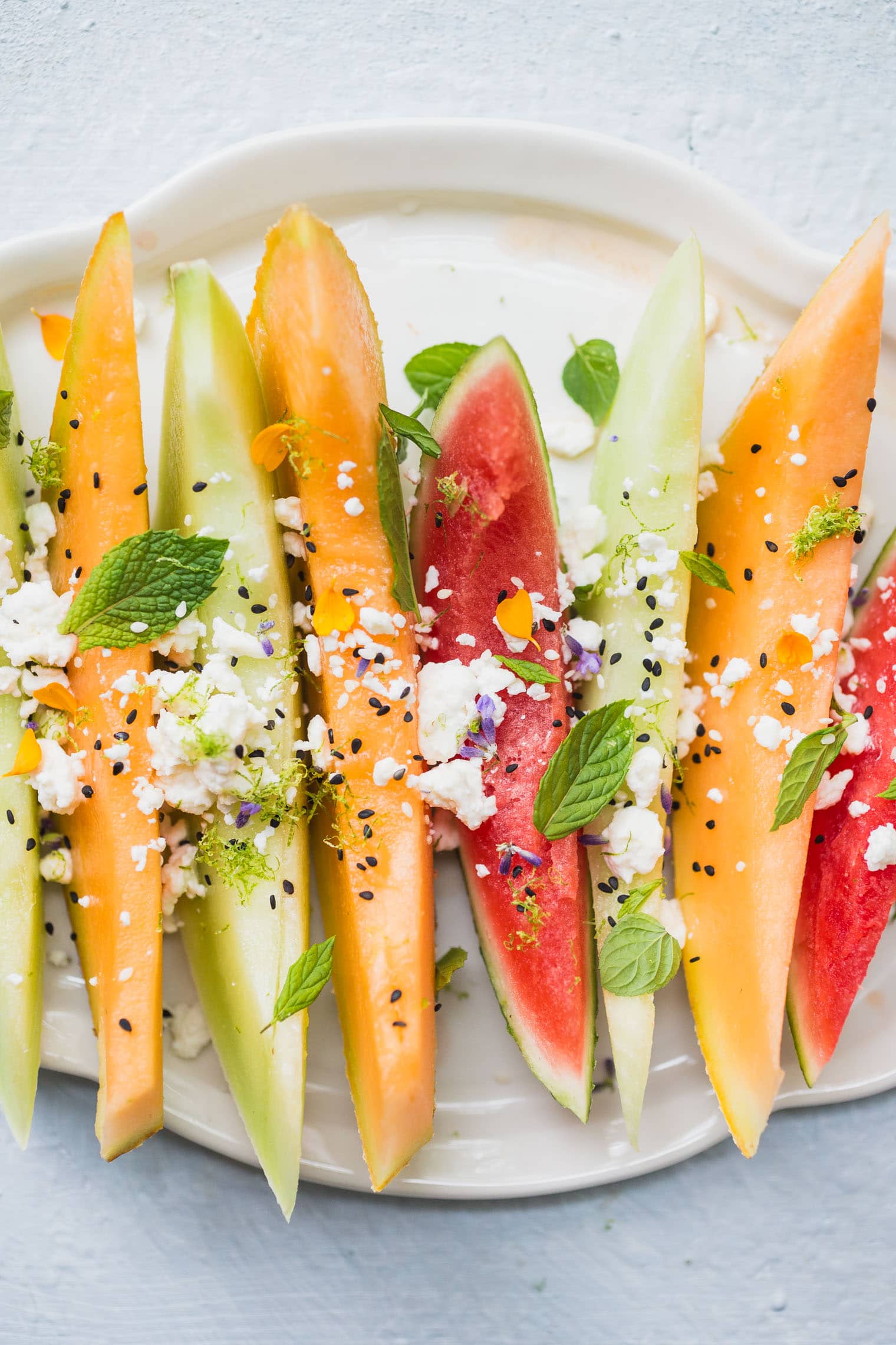 melon salad with feta and mint on white platter