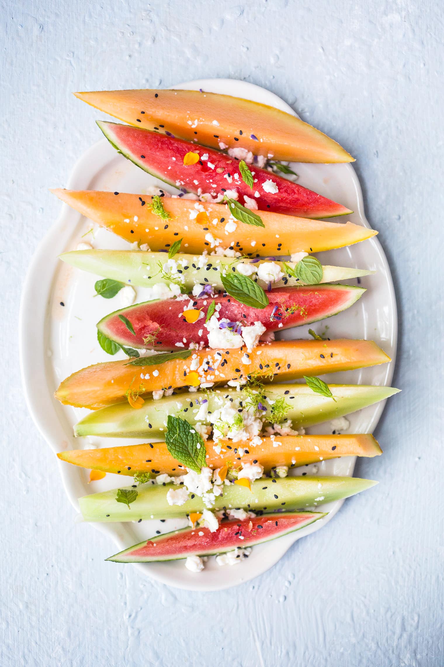 melon salad with feta and mint on white platter