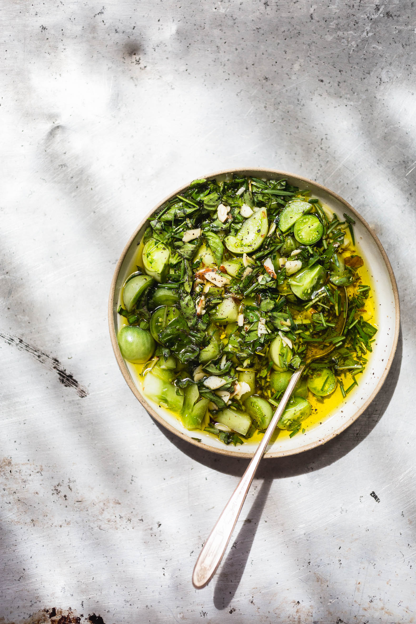 overhead view of Herb and Green Tomato Salsa on white dish with spoon