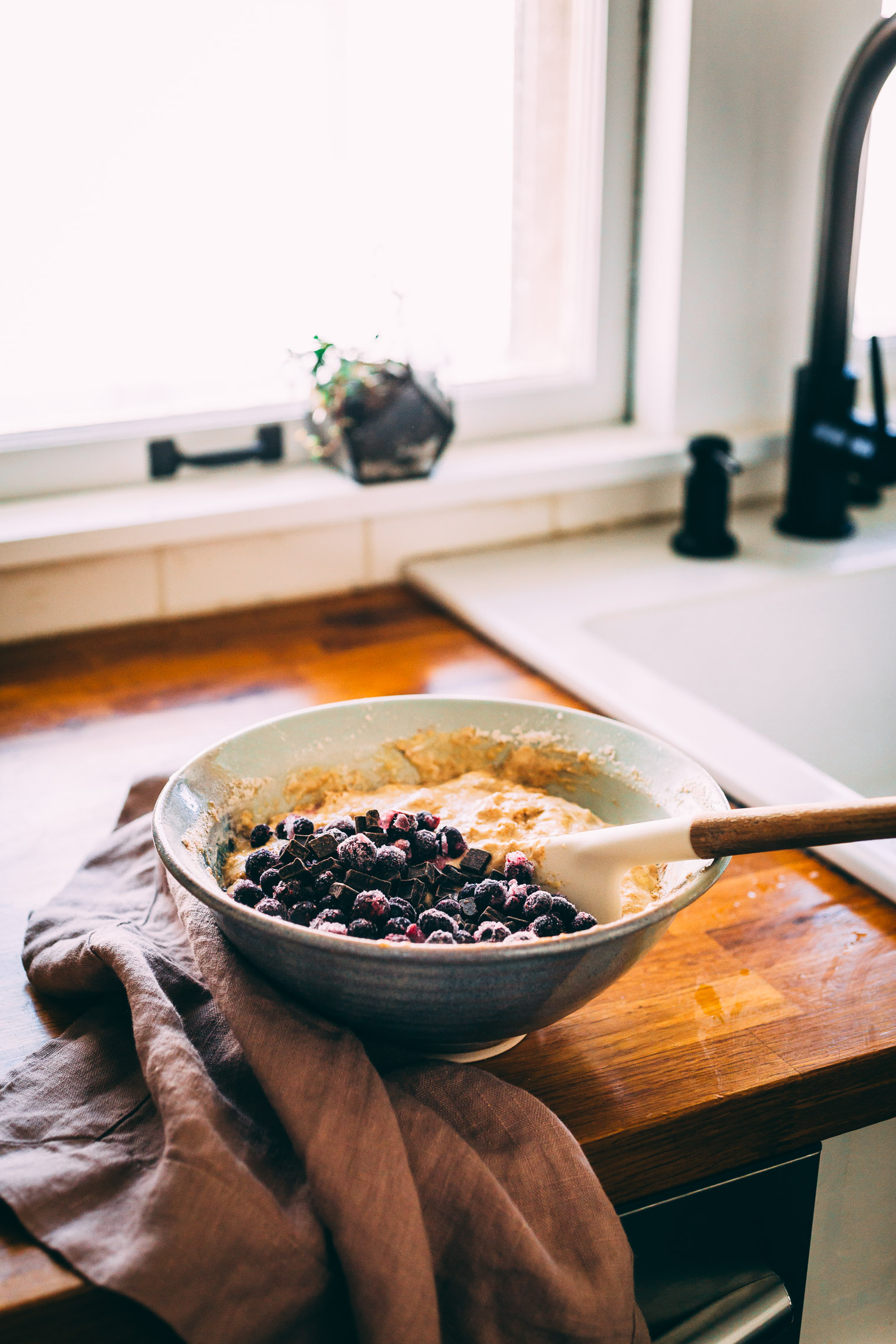 banana chocolate blueberry muffin batter in bowl near kitchen sink