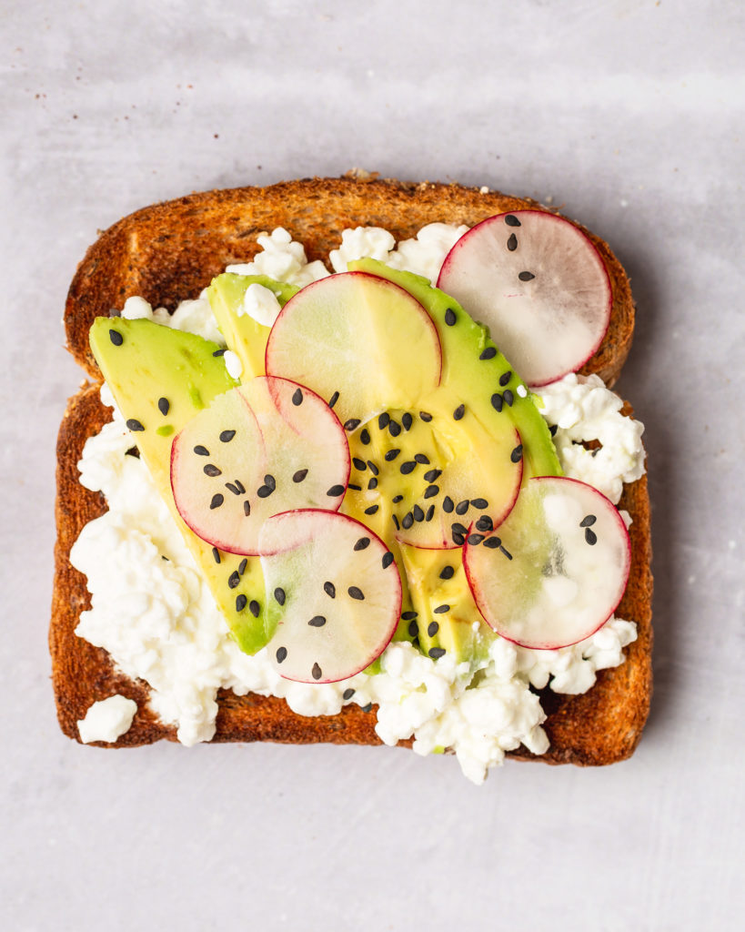 Cottage Cheese on Toast topped with avocado, radish, and sesame seeds