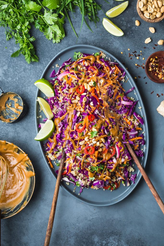 thai quinoa salad on serving platter drizzled with peanut butter salad dressing