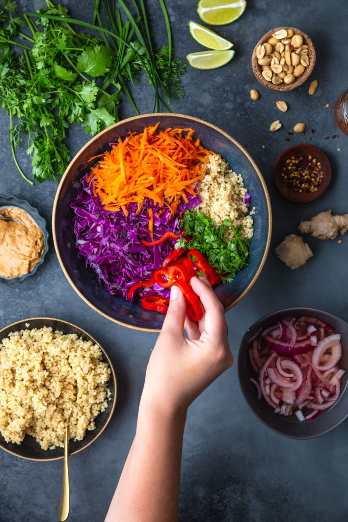 assembling a thai salad with quinoa