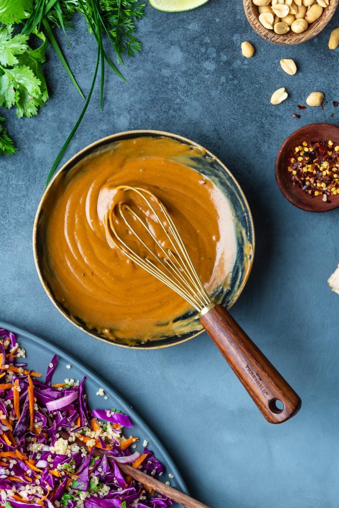 thai peanut butter dressing in bowl with whisk