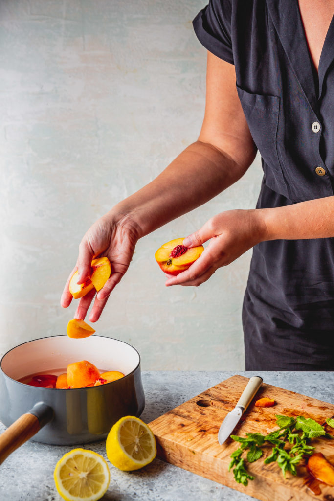 adding sliced peaches to saucepan 