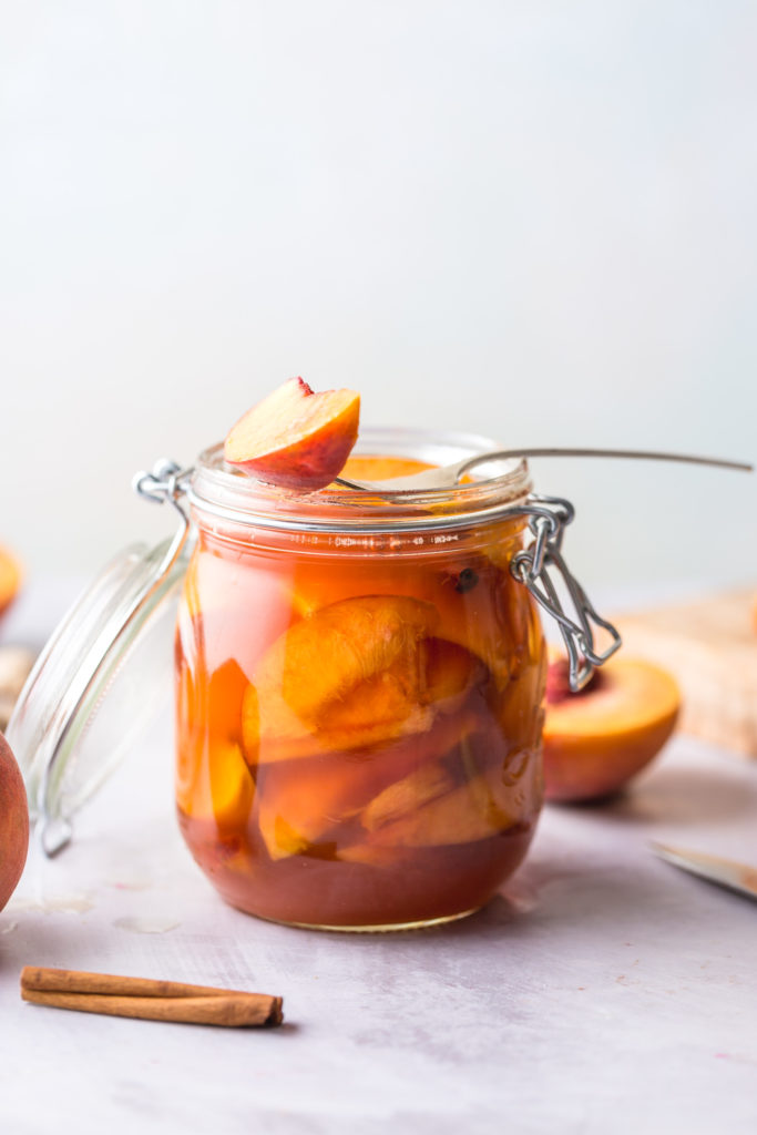 jar of pickled peaches with fork balanced on top