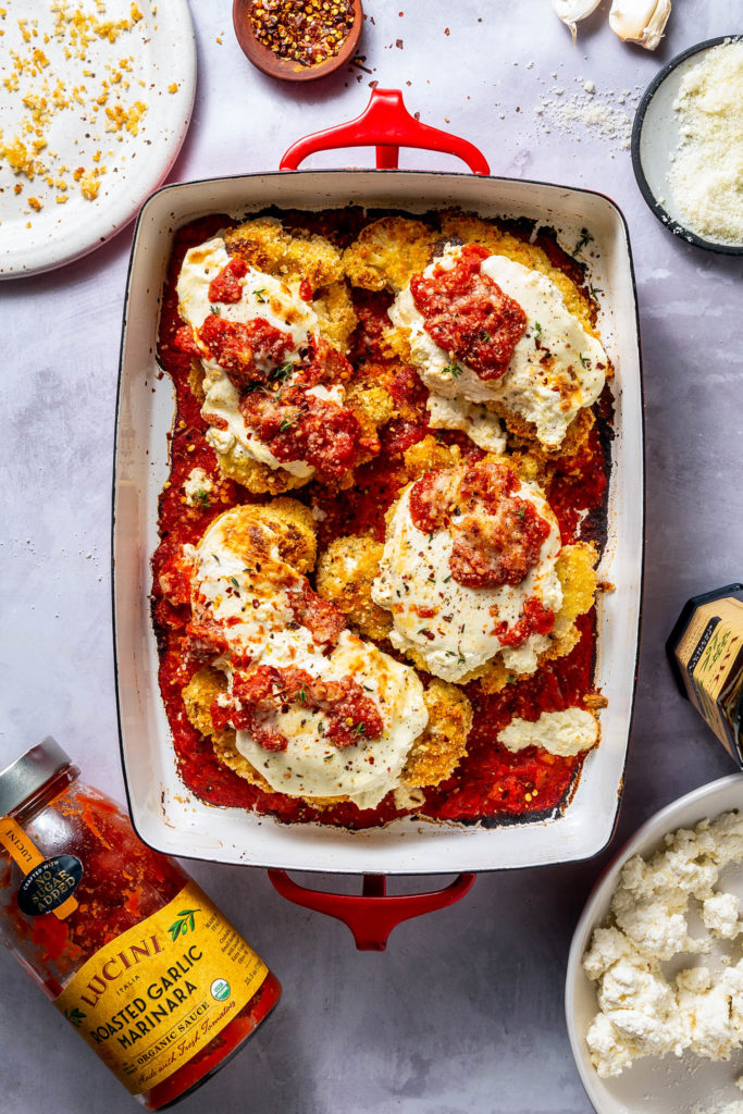 four cauliflower parmesan steaks in baking dish