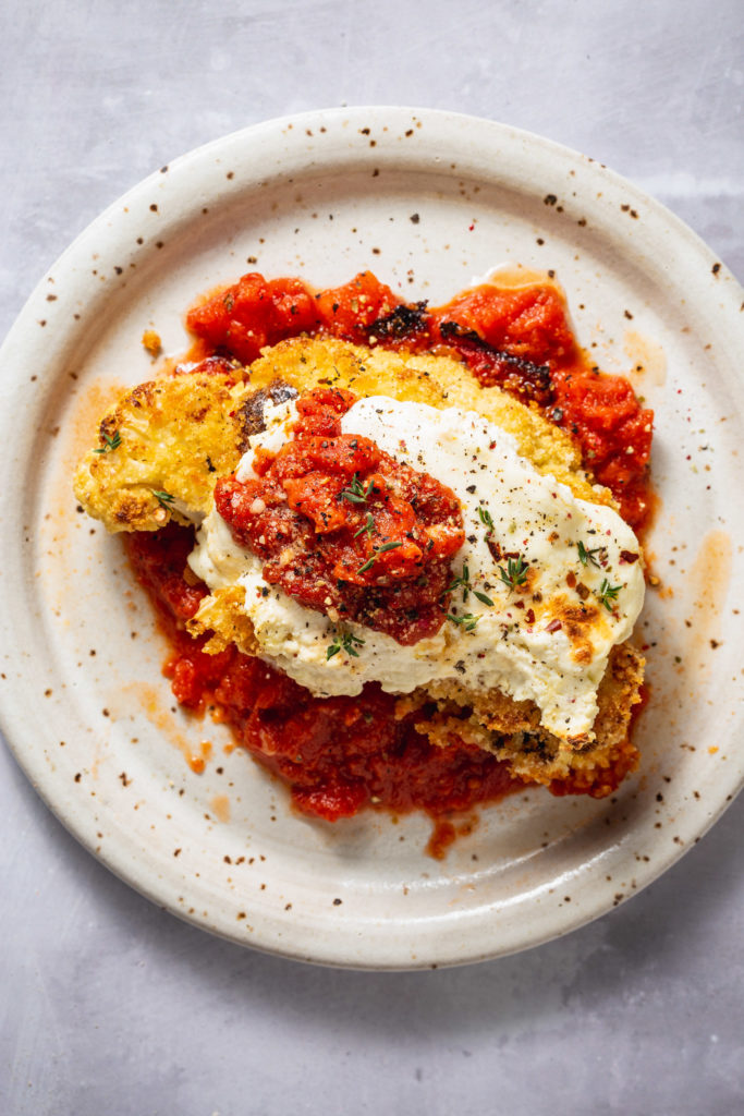 roasted cauliflower parmesan serving on white speckled plate