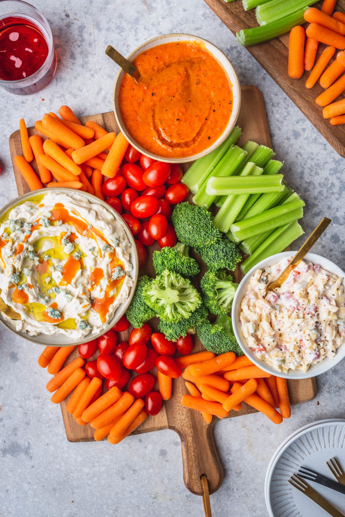 3 easy dips in bowls on wood platter with fresh veggies