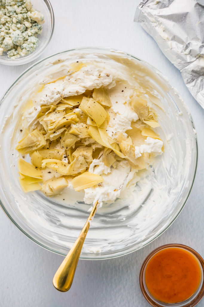 buffalo artichoke dip in glass bowl