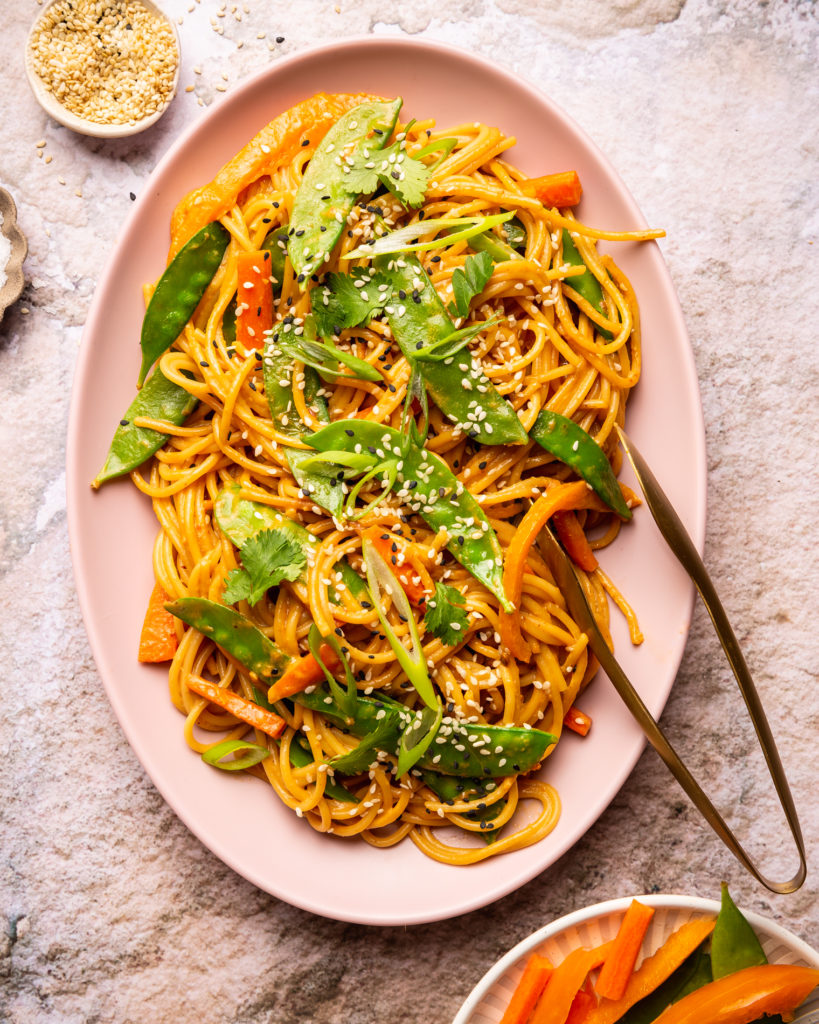 overhead view of Sesame Peanut Noodles on pink serving platter