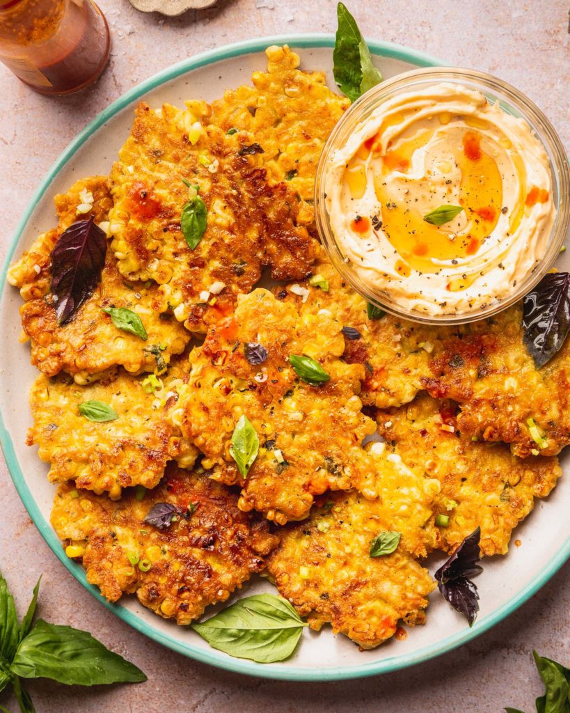 corn fritters with the hot honey whipped butter sauce on a plate