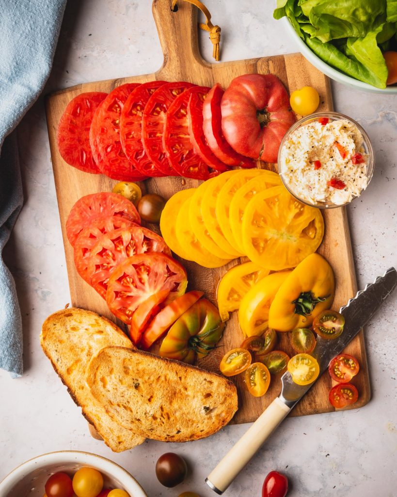 plate of Smoked Gouda Pimento, Lettuce, and Tomato Sandwich being prepared