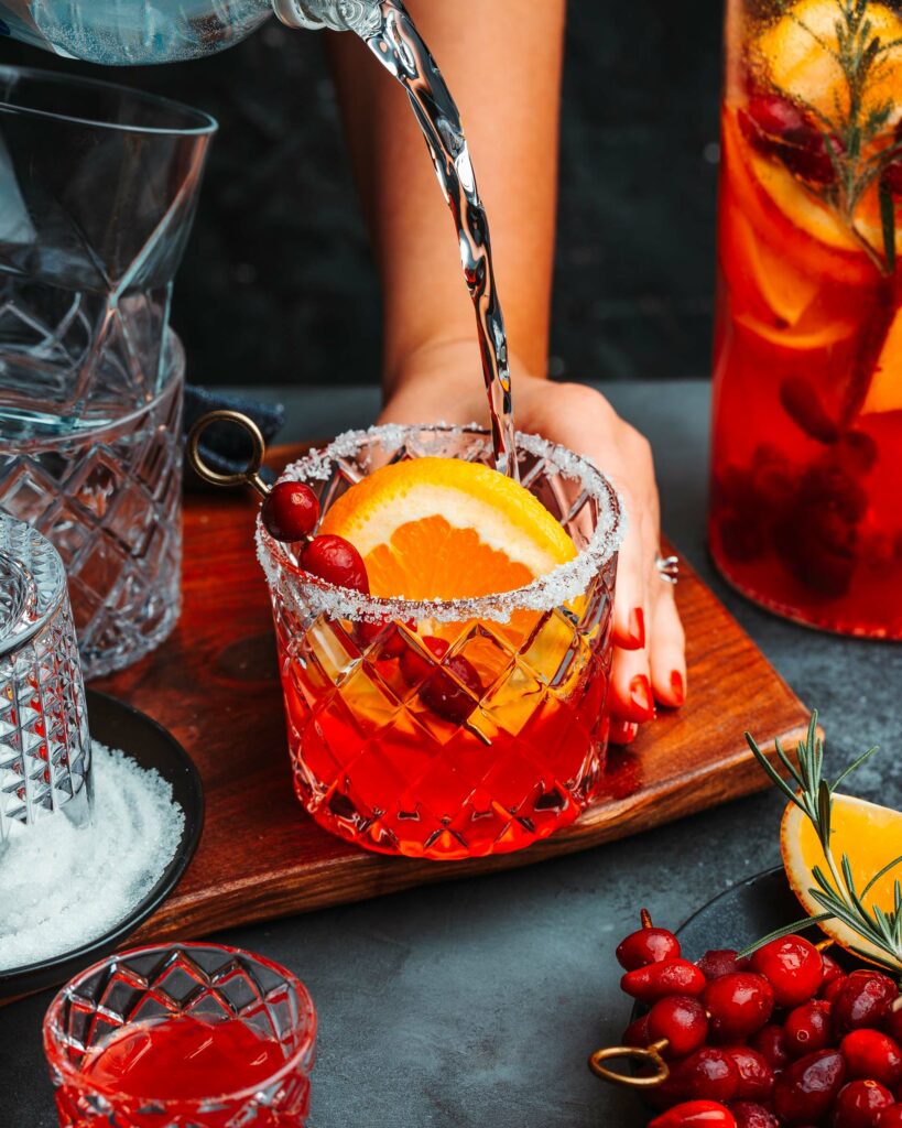 hang pouring sparkling water into the Sparkling Cranberry Orange Margarita