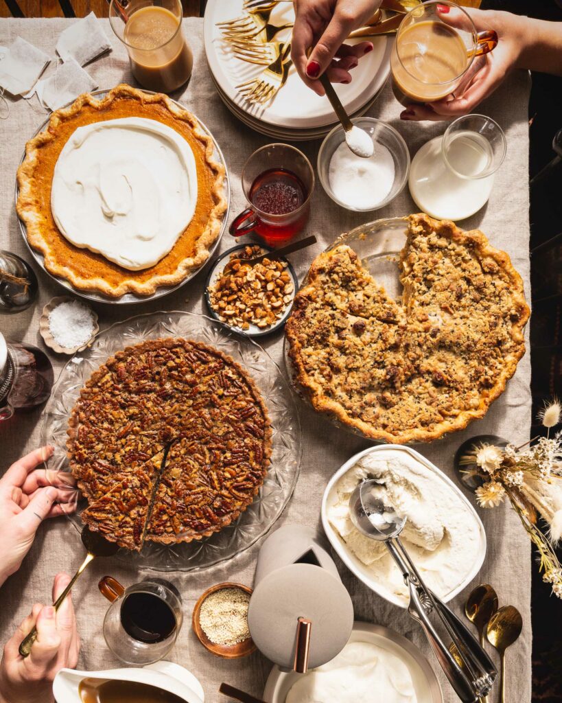 big table spread of thanksgiving pies